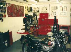 The tidy end of the workshop, the two longer stay ramps with an ex bath tub 5TA well into the restoration process, an A65 in the early stages and a Rocket Goldie on the floor awaiting a service.